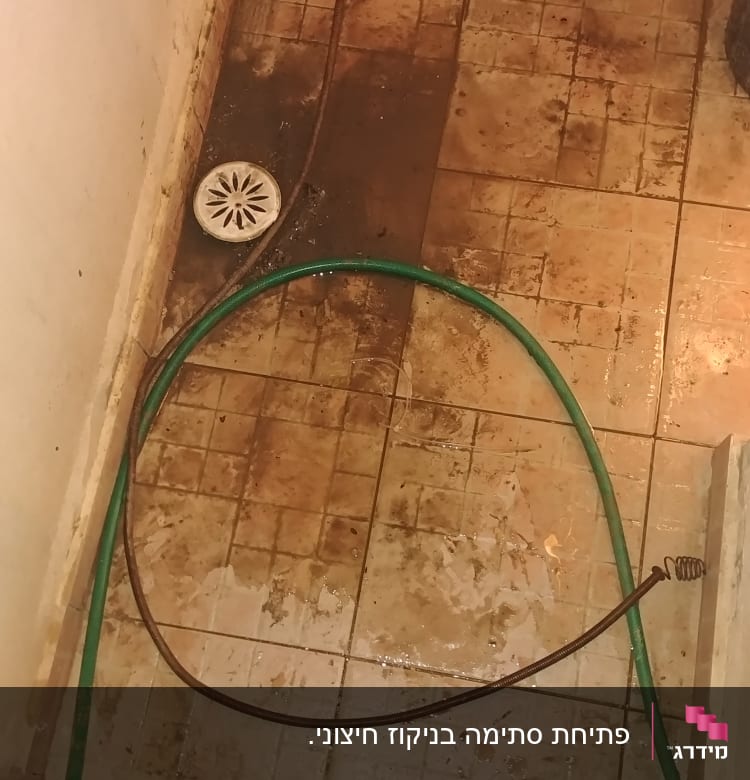 צינור ירוק על רצפה רטובה עם ניקוז